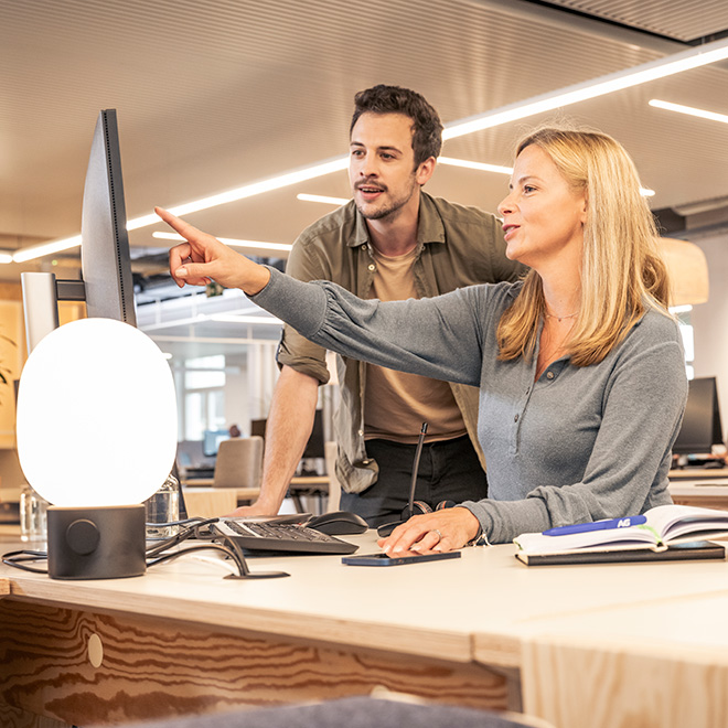 twee collega's bekijken samen een scherm